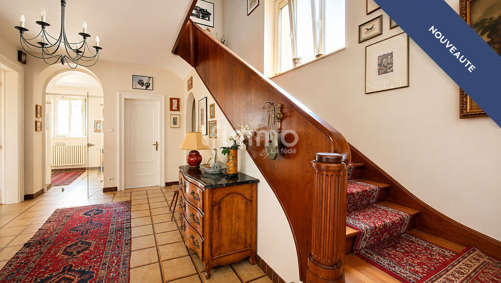 Intérieur d’une maison bourgeoise à Barr Intérieur d'une maison bourgeoise avec un escalier central en bois et des décorations murales.