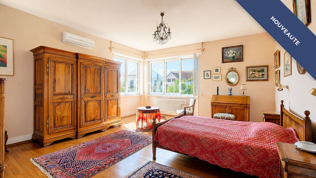 Chambre dans une maison bourgeoise à Barr Chambre d'une maison bourgeoise à Barr, avec lit, armoire en bois et vue sur l'extérieur.
