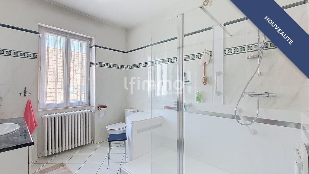 Salle de bain élégante Salle de bain moderne avec douche et baignoire, carrelage blanc et fenêtre lumineuse.