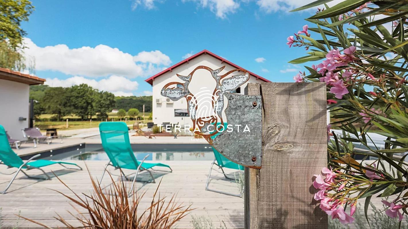 Domaine de l'Anglade avec piscine et chaises longues dans un parc verdoyant