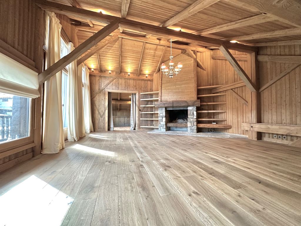 Intérieur d’un chalet à Megève Intérieur d'un chalet en bois avec cheminée et grandes fenêtres, espace vide.