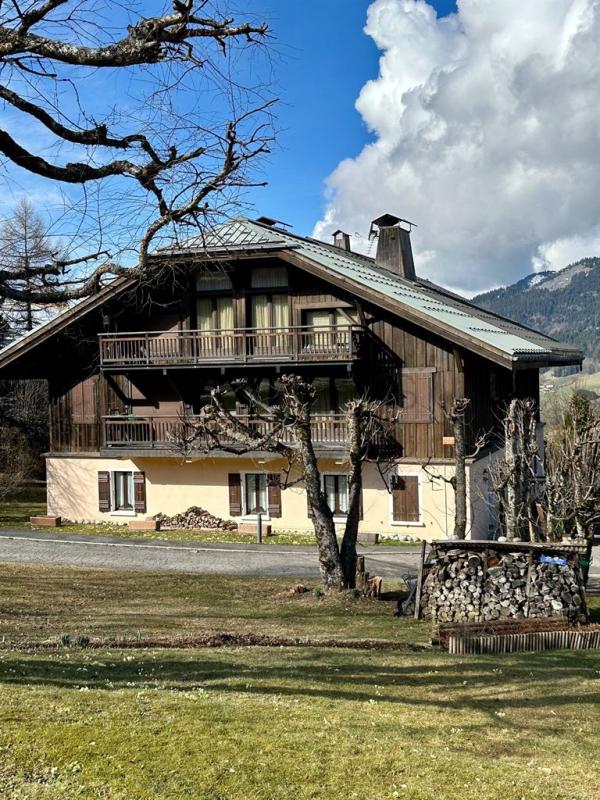 Chalet à Megève Chalet en duplex à Megève, entouré de verdure, avec balcons et cheminée.
