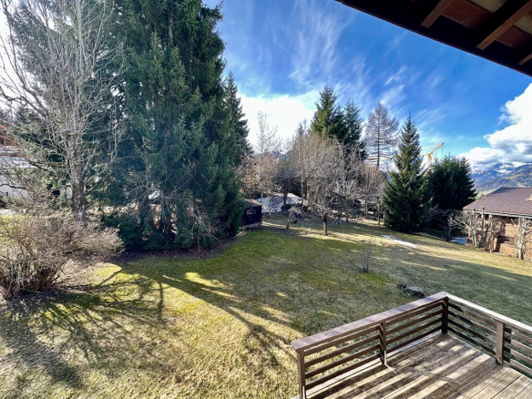 Vue extérieure d'un chalet avec un jardin et des arbres à Megève.