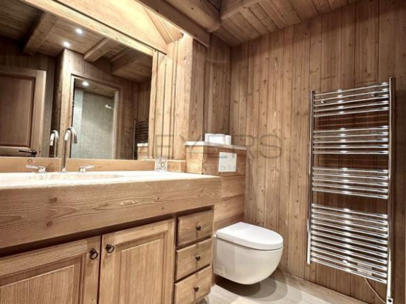 Salle de bains en bois avec lavabo et toilettes dans un chalet à Megève.