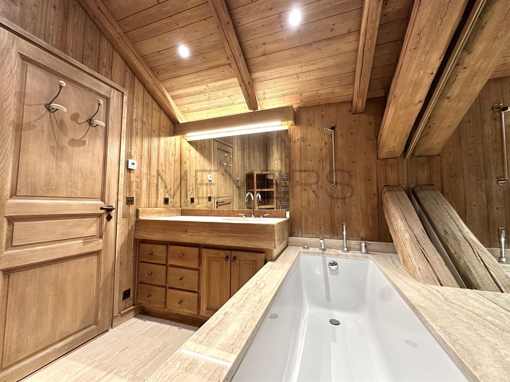 Salle de bain du chalet à Megève Salle de bain en bois avec baignoire et miroir, chalet à Megève