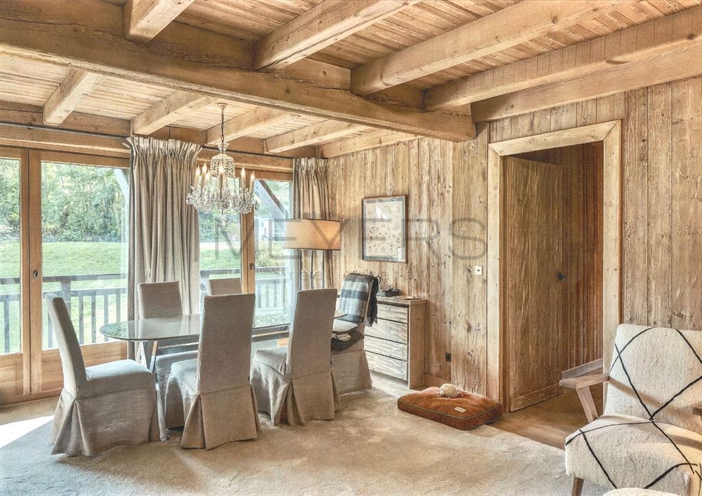 Intérieur d’un chalet à Megève Intérieur d'un chalet à Megève avec salle à manger en bois et vue sur la nature.