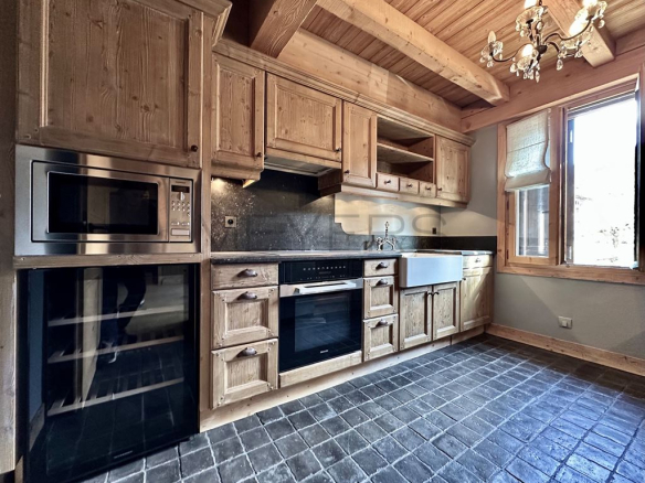 Cuisine en bois dans un chalet rénové à Megève avec équipements modernes.