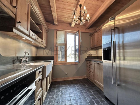Cuisine d'un chalet rénové à Megève avec des éléments en bois et des appareils modernes.