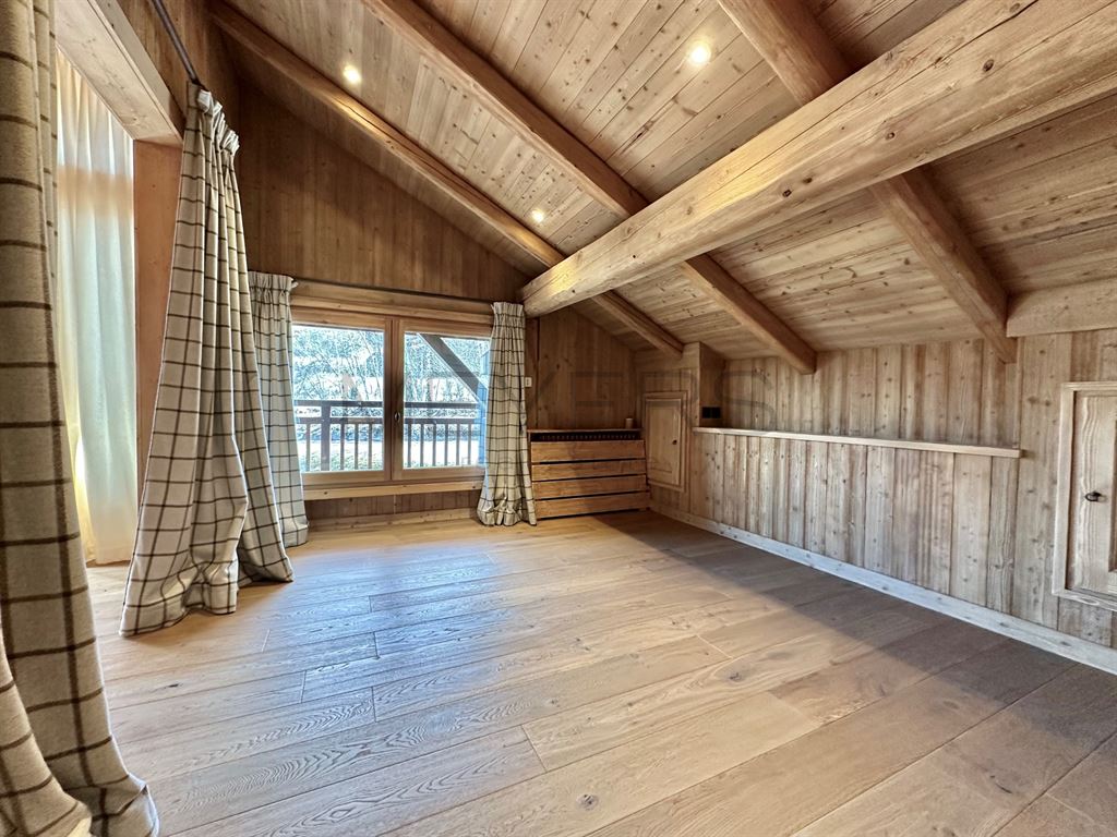 Intérieur d’un chalet à Megève Intérieur d'un chalet en bois avec des poutres apparentes et de grandes fenêtres.