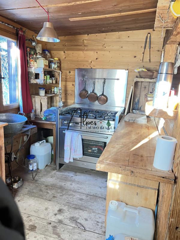 Intérieur d’un chalet d’alpage Intérieur d'un chalet d'alpage avec cuisine en bois et équipements de cuisine.