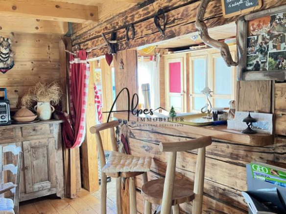 Intérieur d'un chalet d'alpage en bois, avec bar et décoration rustique.