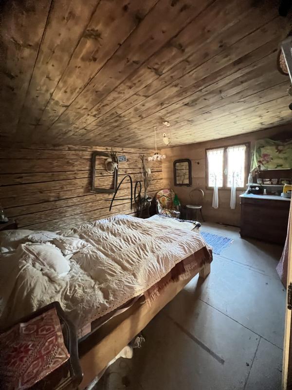 Intérieur d’un chalet d’alpage Intérieur d'un chalet d'alpage avec un lit en bois et des murs en bois, ambiance chaleureuse et rustique.