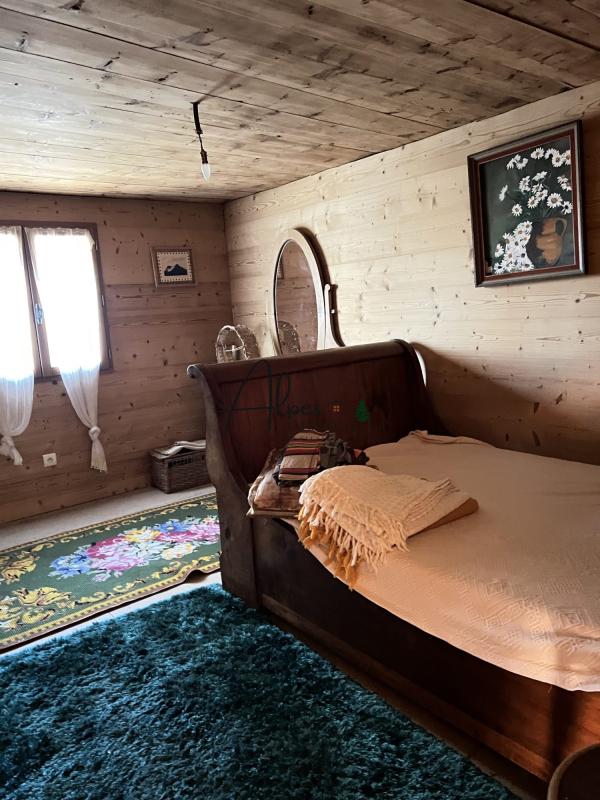Chambre d’un chalet d’alpage Chambre d'un chalet d'alpage avec un lit en bois et un tapis vert, décorée de manière authentique.