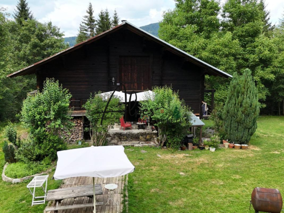 Chalet d'alpage en bois entouré d'arbres et d'un jardin verdoyant à La Clusaz.