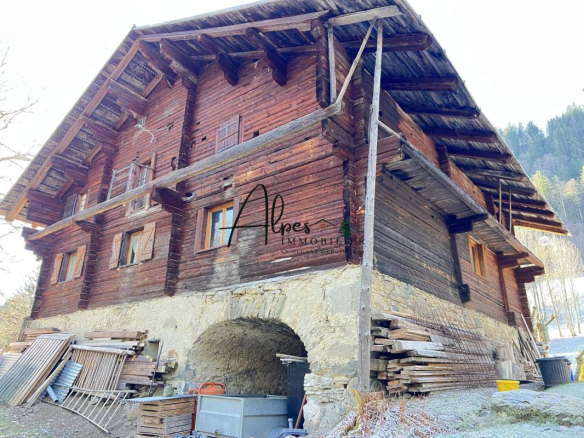 Chalet d'alpage en bois avec murs en pierre, entouré de nature, à La Clusaz.