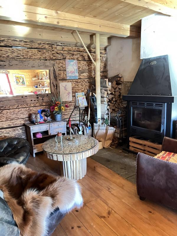 Intérieur d’un chalet d’alpage Intérieur d'un chalet d'alpage avec un salon en bois, cheminée et mobilier rustique.