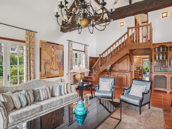 Intérieur d'une somptueuse propriété avec salon élégant et escalier en bois.