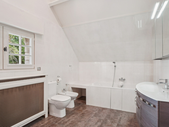 Salle de bain moderne avec baignoire et toilettes dans une propriété de prestige.