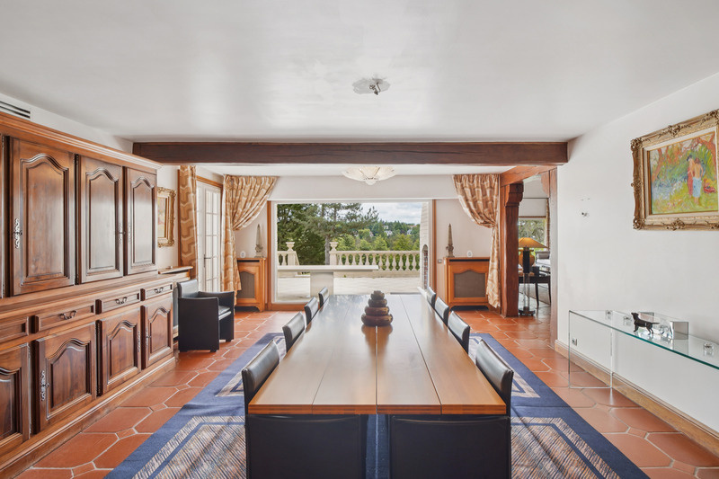 Salle à manger d’une propriété de prestige Intérieur d'une salle à manger élégante avec une grande table et des fenêtres donnant sur un paysage verdoyant.