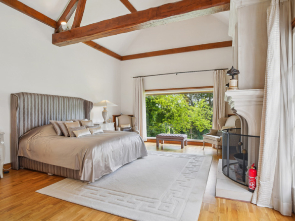 Chambre élégante avec lit king-size et vue sur le jardin, située dans une propriété de prestige.