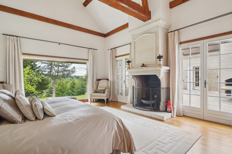 Chambre de prestige au Golf de Saint-Nom-la-Bretèche Chambre élégante avec cheminée et vue sur le jardin dans une propriété au Golf de Saint-Nom-la-Bretèche.