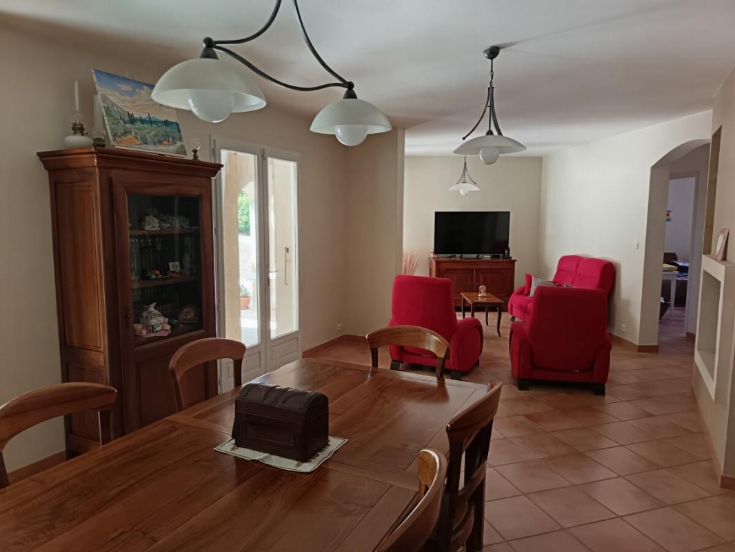 Intérieur d’une maison à Toulon Intérieur d'une maison à Toulon avec salle à manger et salon, mobilier en bois et fauteuils rouges.