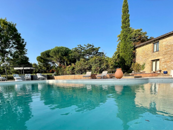 Piscine d'un corps de ferme rénové à La Sauzière-Saint-Jean avec vue sur le parc.