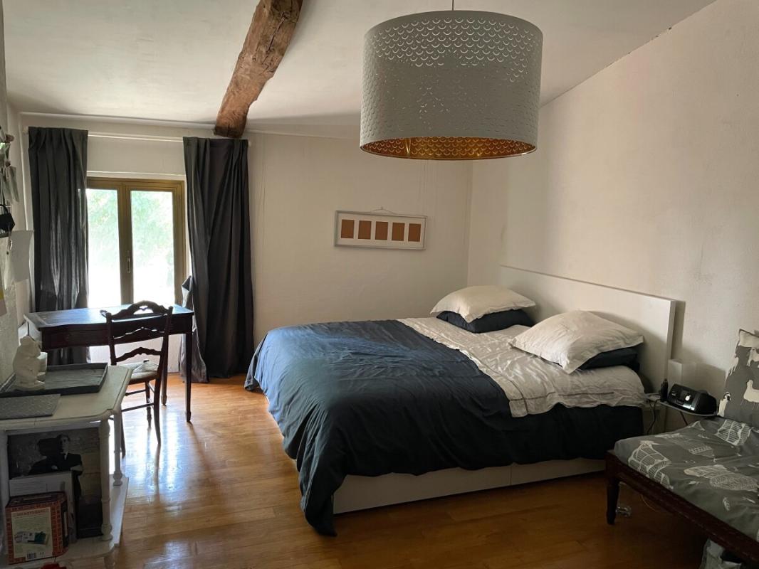 Chambre dans un corps de ferme rénové Chambre spacieuse avec lit double et bureau, décorée sobrement.