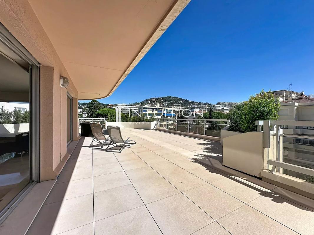 Spacious terrace of an apartment in Cannes with unobstructed views and garden furniture.