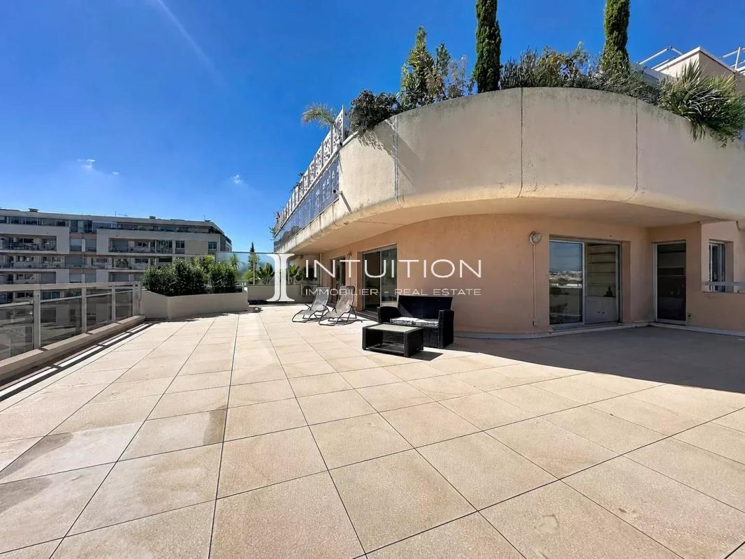 Spacious terrace of an apartment in Cannes with garden furniture.