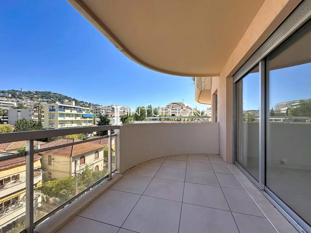 Balcony of an apartment in Cannes with a view of the city and the blue sky.