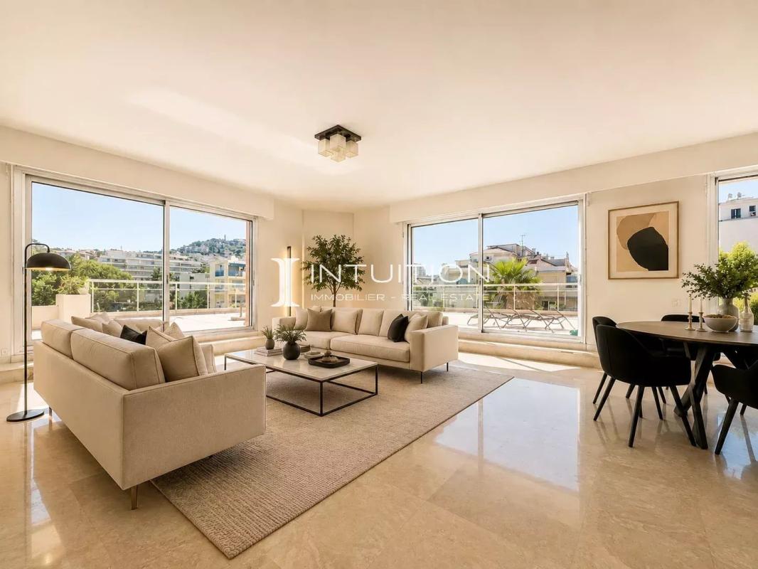 Interior of a bright apartment with living room and dining room, large windows, and unobstructed view.