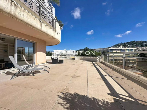 Spacious terrace of an apartment in Cannes with sun loungers and unobstructed views.