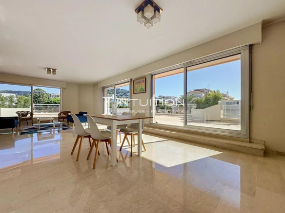 Interior of a bright apartment with dining room and large windows in Cannes.