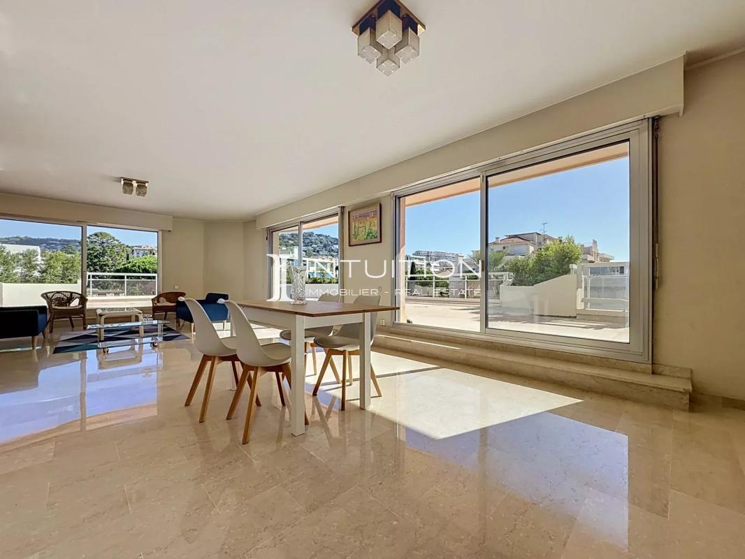 Interior of a bright apartment with dining room and large windows in Cannes.