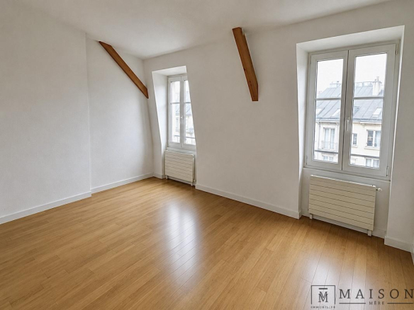 Intérieur d'un appartement de 102m2 au dernier étage, avec fenêtres et parquet clair.