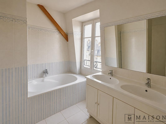 Salle de bains avec baignoire et double vasque dans un appartement au dernier étage à Paris 6ème.