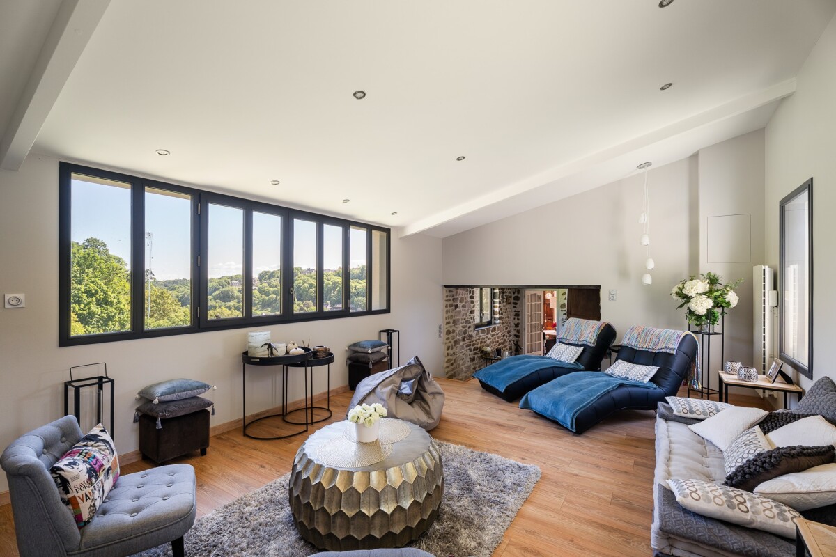 Salon lumineux dans une maison en pierre Intérieur d'une maison en pierre avec salon lumineux et vue sur la nature.