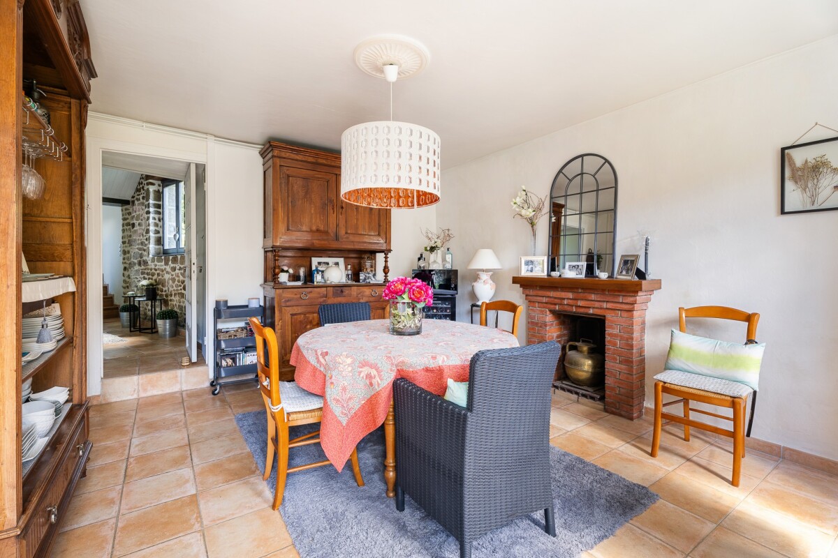 Salle à manger d’une maison en pierre à Dinan Intérieur d'une maison en pierre avec salle à manger lumineuse et cheminée.