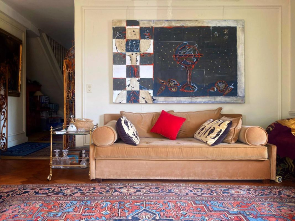 Intérieur d'un duplex avec un canapé en velours et une œuvre d'art au mur, Strasbourg.
