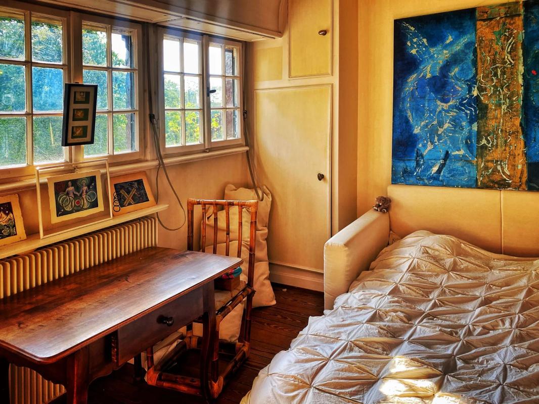 Intérieur d’un duplex à Strasbourg Intérieur d'un duplex lumineux avec mobilier en bois et tableau coloré, fenêtres donnant sur l'extérieur.