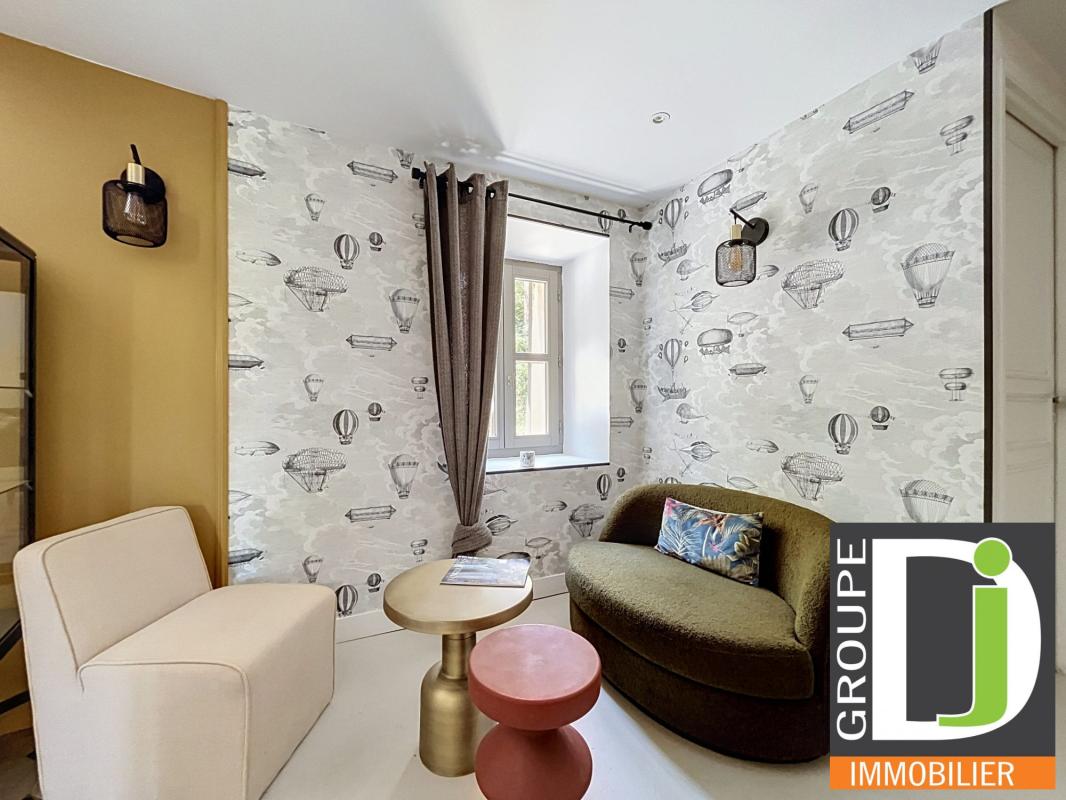 Intérieur de bastide rénovée à Montmeyran Intérieur d'une bastide rénovée avec un salon moderne et des décorations murales.