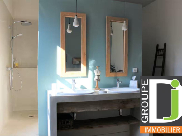 Salle de bain moderne avec deux lavabos et douche, murs peints en bleu et beige.
