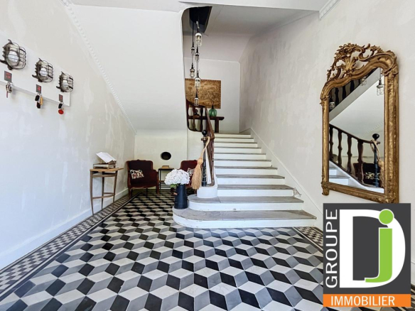 Intérieur d'une bastide du XIXe siècle avec escalier et carrelage en damier noir et blanc.