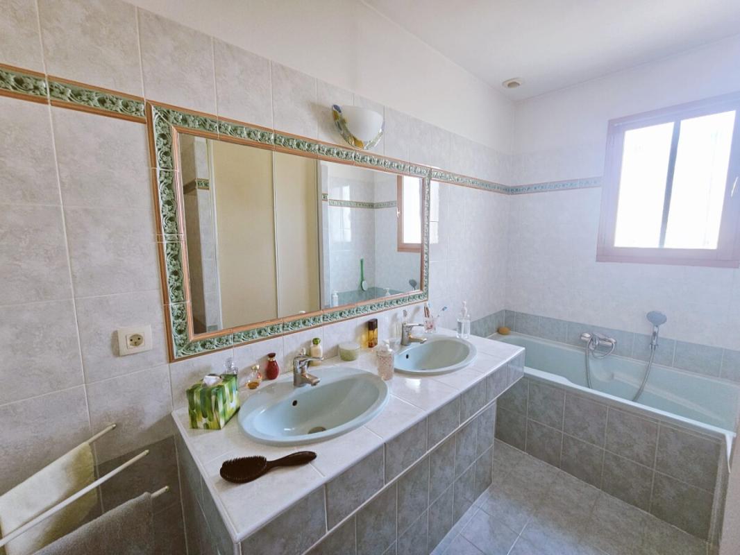 Bathroom with double vanity and bathtub, natural light