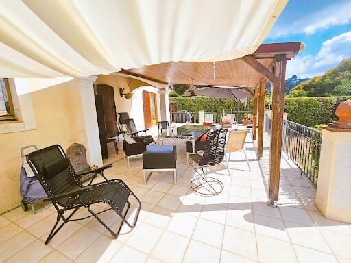 Terrace of a villa in Le Cannet with outdoor furniture and garden view.