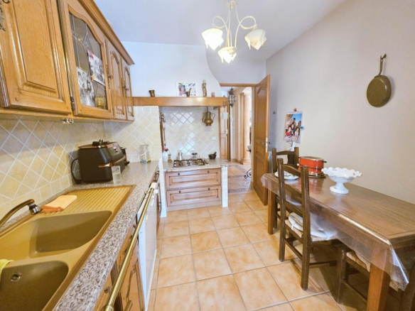 Kitchen of a villa in Le Cannet with wooden furniture and dining table.