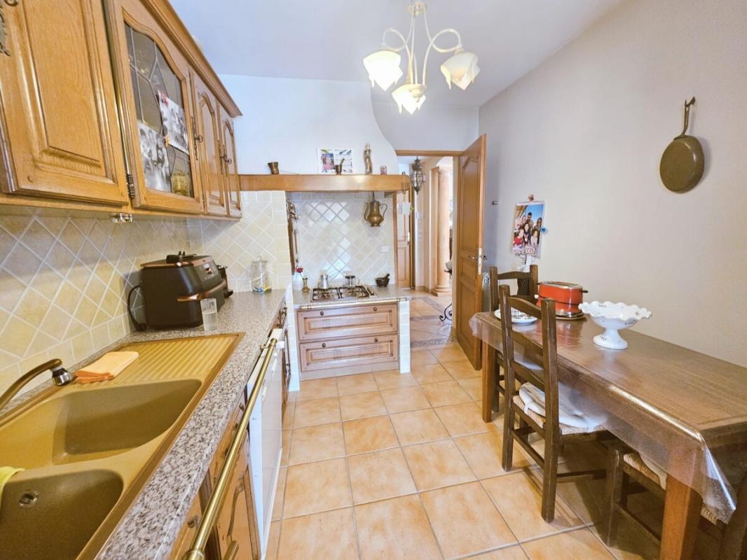 Kitchen of a villa in Le Cannet with wooden furniture and dining table.