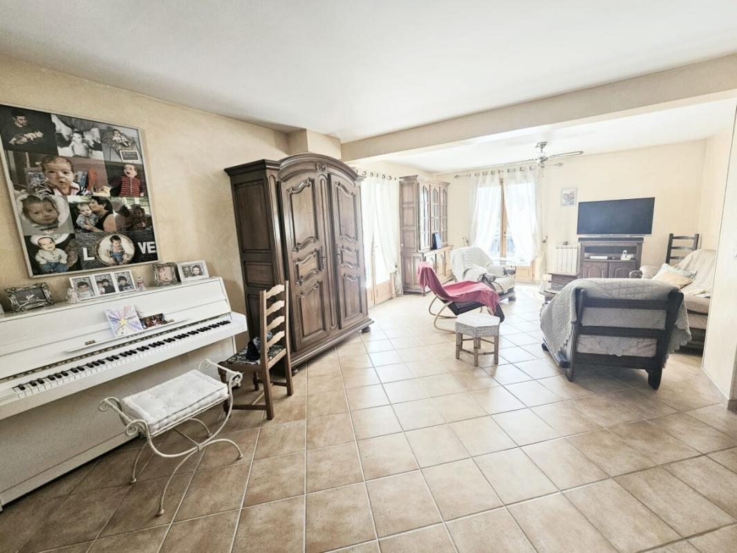 Interior of a family villa with a bright living room, a piano and wooden furniture.