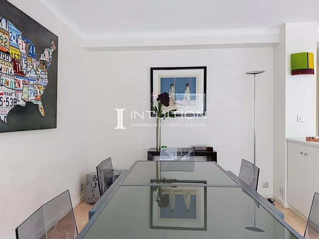 Bright apartment in Cannes Interior of a bright apartment with a large glass table and transparent chairs.